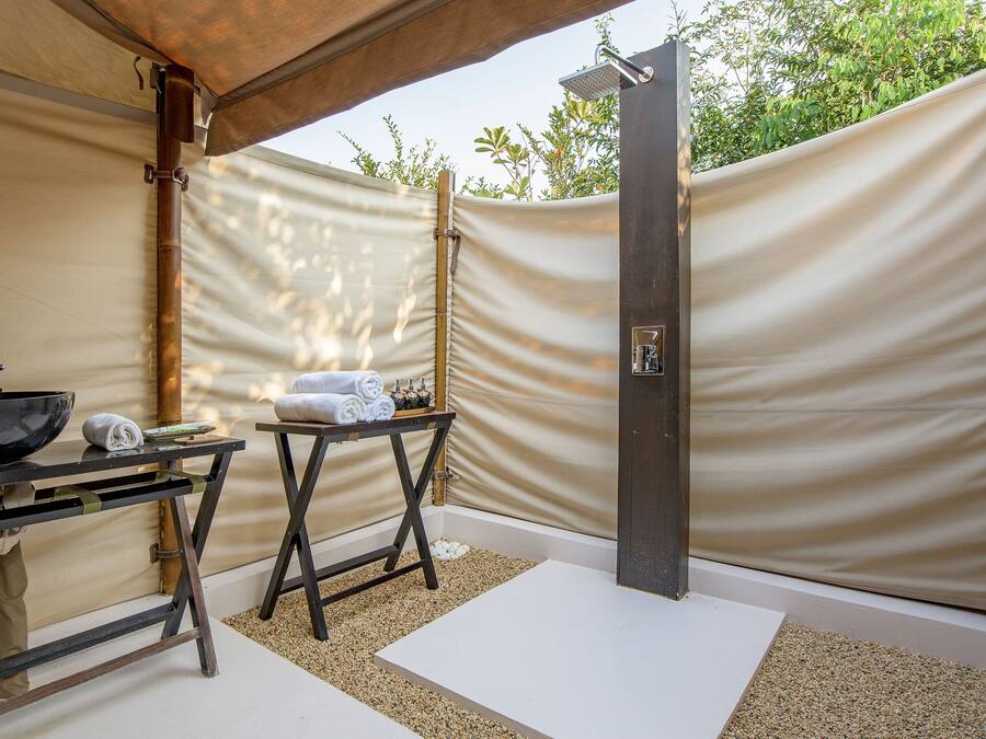 A spa area with a black sink, towels, and a shower.