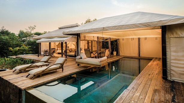 A poolside area with lounge chairs and a covered seating area. - The Beige (Angkor Thum)