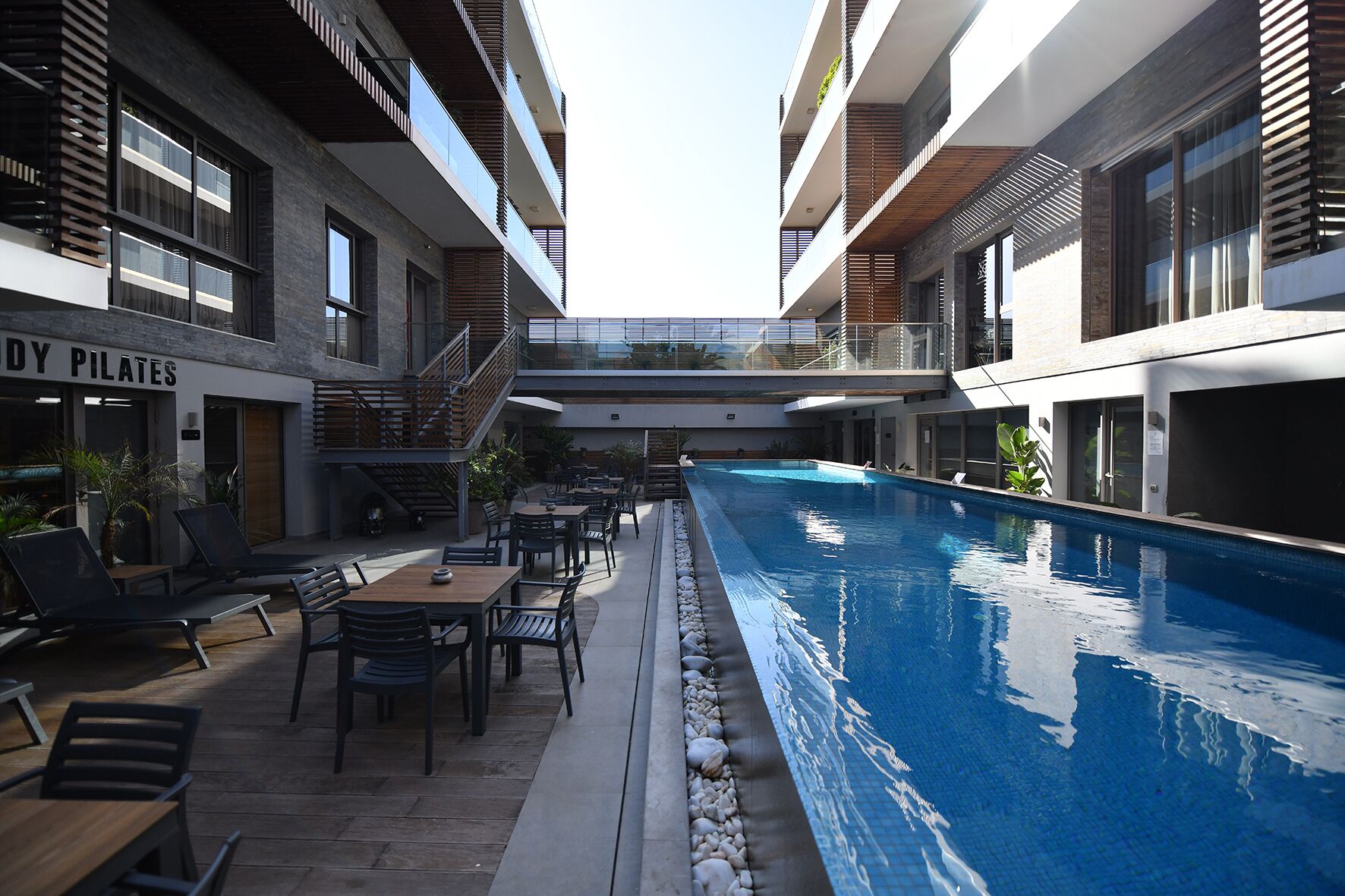 Un edificio moderno con piscina, area relax all'aperto e sala Pilates.