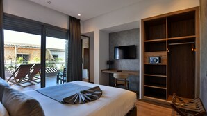 Une chambre d’hôtel moderne équipée d’un grand lit, d’un bureau, d’une télévision et d’une armoire.