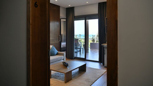 Une chambre d’hôtel moderne avec un canapé, une table basse et vue sur le balcon.