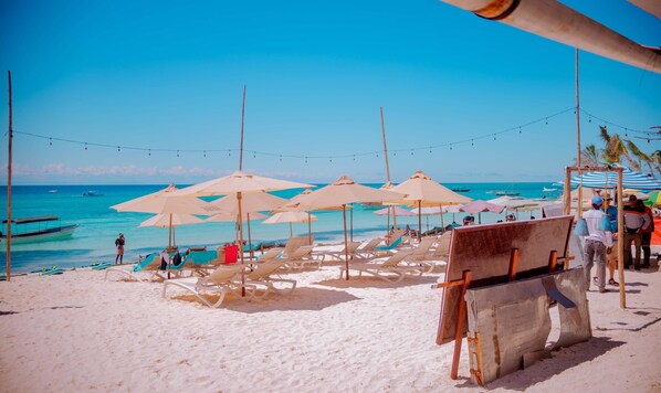 Aan het strand, ligstoelen aan het strand, parasols, strandlakens