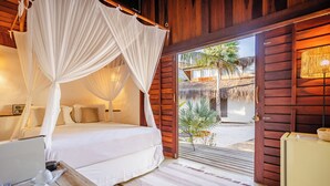 Un dormitorio con cama, mesita de noche y dosel.