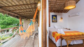 A room with a bed, a hammock, and a wooden table. - Pousada Titas (Cajueiro da Praia)