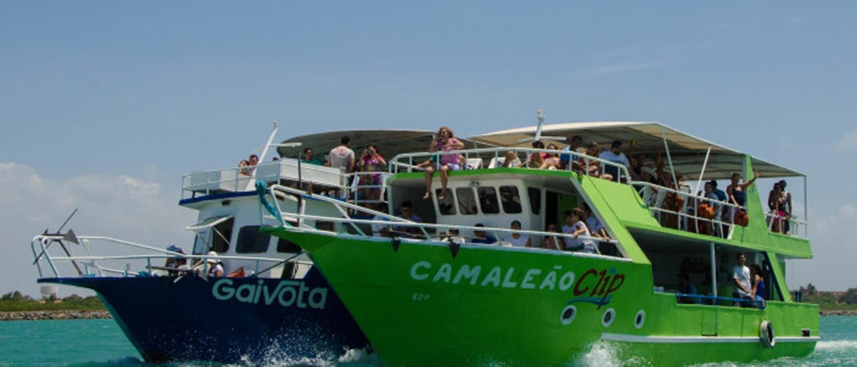 Duas embarcações com passageiros, uma identificada como 'GaiVota' e a outra como 'Camaleão Chip'.