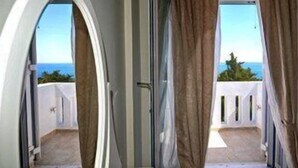 Un pasillo que da a un balcón con vista al mar.