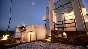 Un edificio moderno con fachada de piedra, un balcón y una escalera que conduce a la entrada.