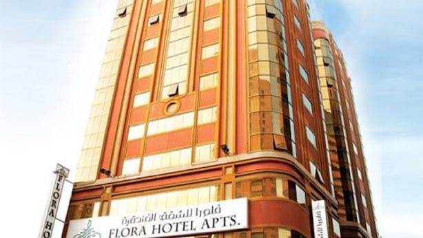 A tall hotel building with a sign reading "Flora Hotel Apts." - Florida City Hotel Apartments (Dubai)