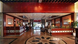 A hotel lobby with a reception desk, seating area, and a large decorative floor pattern. - Florida City Hotel Apartments (Dubai)
