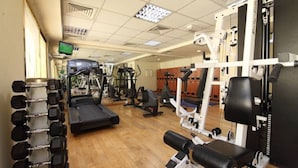 A gym with treadmills, weight machines, and free weights. - Florida City Hotel Apartments (Dubai)