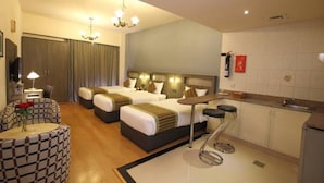 A hotel room with two beds, a kitchenette, a dining area, and a bathroom. - Florida City Hotel Apartments (Dubai)
