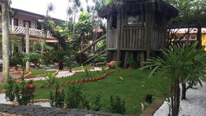 A treehouse structure surrounded by lush greenery and a stone pathway. - Hotel Pousada dos Ventos (Parnaíba)