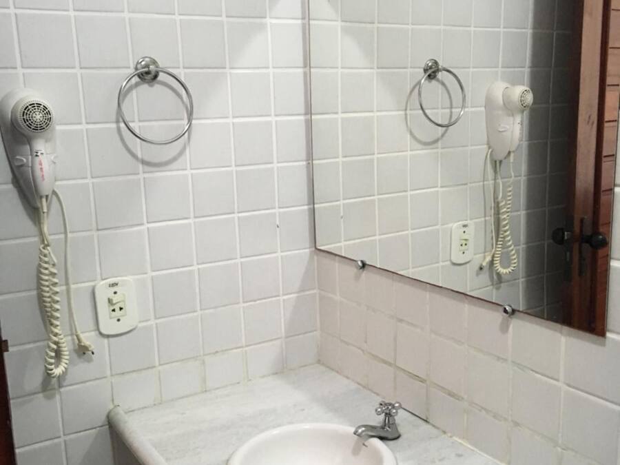 Une salle de bain équipée d’un lavabo, d’un miroir, d’un sèche-cheveux et d’un téléphone.