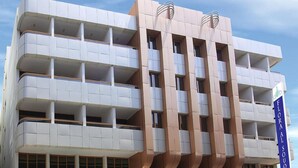 A multi-story hotel with a modern architectural design, featuring balconies and a prominent sign for the Flora Al Souq Hotel. - Florida Al Souq Hotel (Dubai)