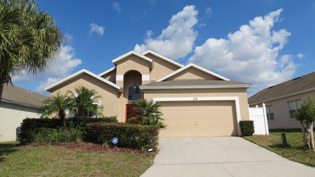 A residential house with a beige exterior, a garage, and a well-maintained lawn. - Pool Homes Davenport Area by SVV (Davenport)