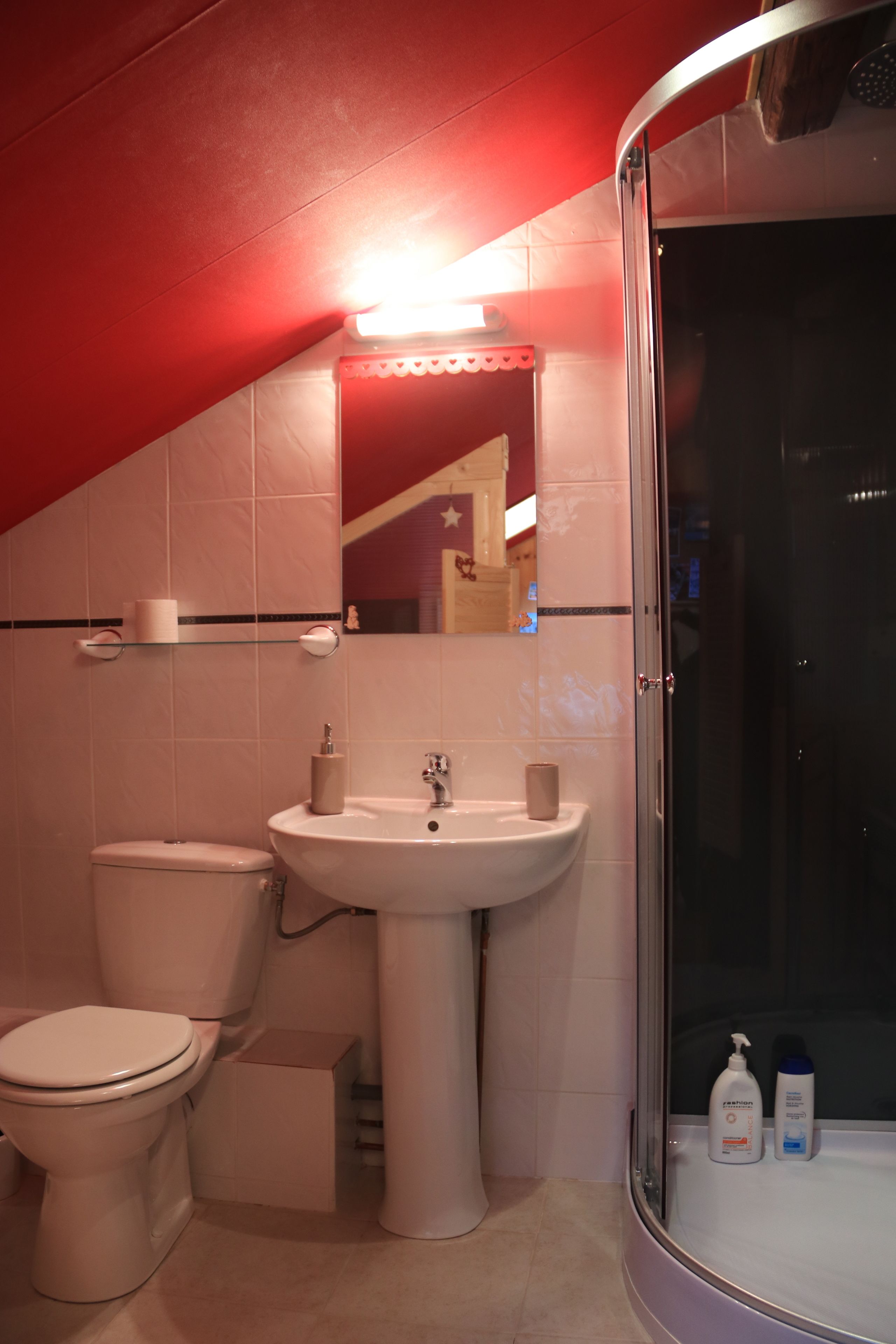 A bathroom with a toilet, sink, and shower.