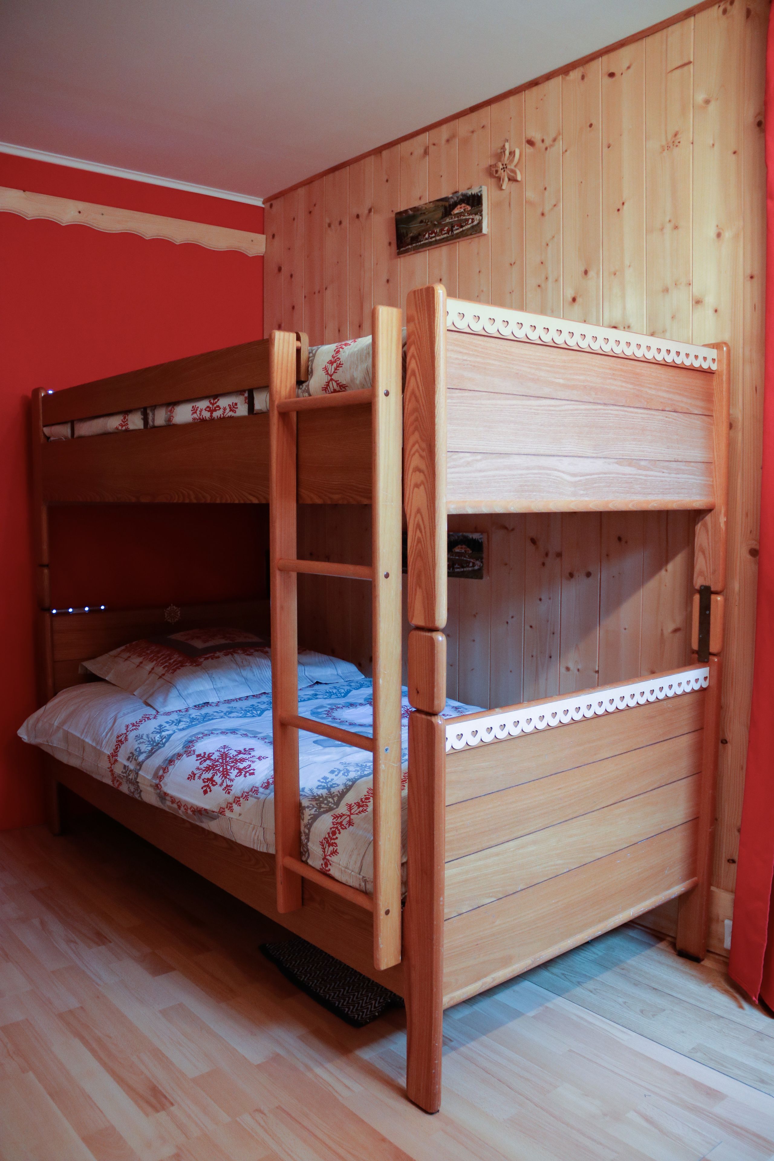 A bunk bed with a wooden frame and a lower bunk.