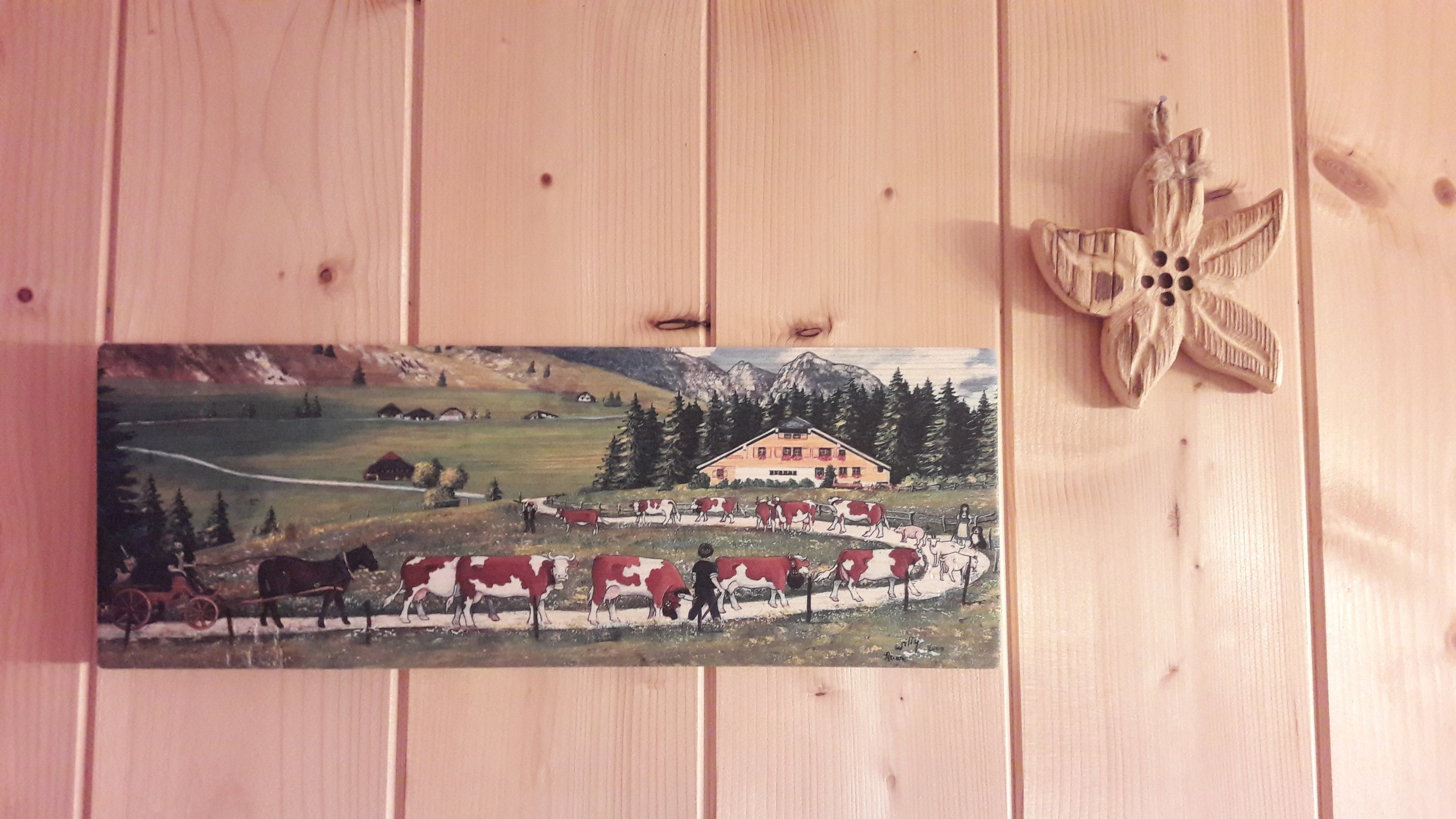 Un tableau représentant un paysage rural avec une maison, des vaches et une montagne.