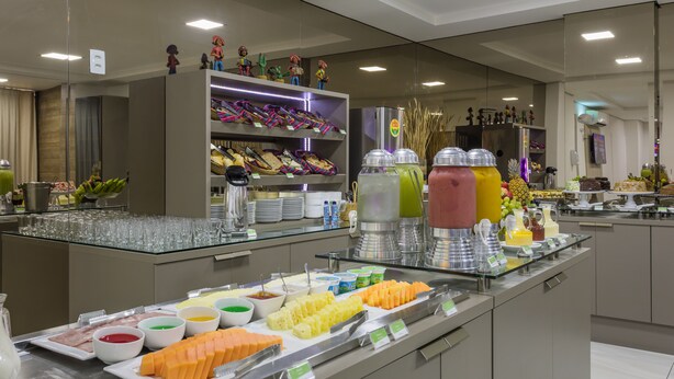 Un buffet proposant une variété de plats et de boissons, notamment des fruits, des fromages et un assortiment de boissons.