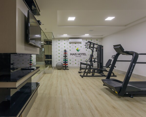A gym with a treadmill, weight machines, and exercise balls. - Nord Easy Patos (Patos)