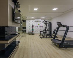 Un gimnasio con cintas de correr, máquinas de pesas y pelotas de ejercicio.