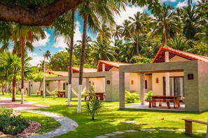 A resort with multiple bungalow-style accommodations, outdoor seating areas, and lush tropical landscaping. - Costa Dourada Village (Maragogi)