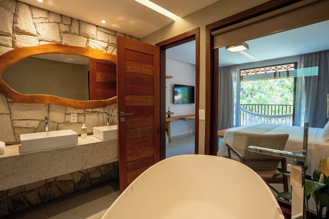 Un bagno moderno con parete in pietra, porta in legno e uno specchio grande.