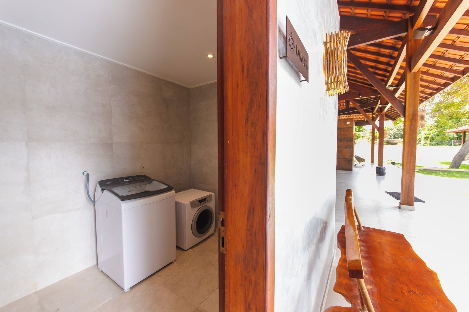 A laundry room with a washing machine and dryer, wooden beams, and a sign on the wall.