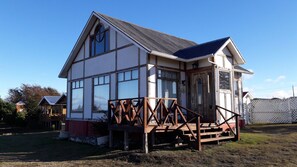 A two-story house with a balcony and a small porch. - Cabañas Cerro Las Piedras (Punta Arenas)