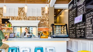 A bar area with stools, a counter, and a chalkboard menu. - Bed & Bike Curacao Hostel (Willemstad)