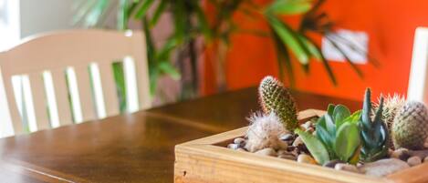 A wooden planter box with various cacti and succulents on a wooden table.