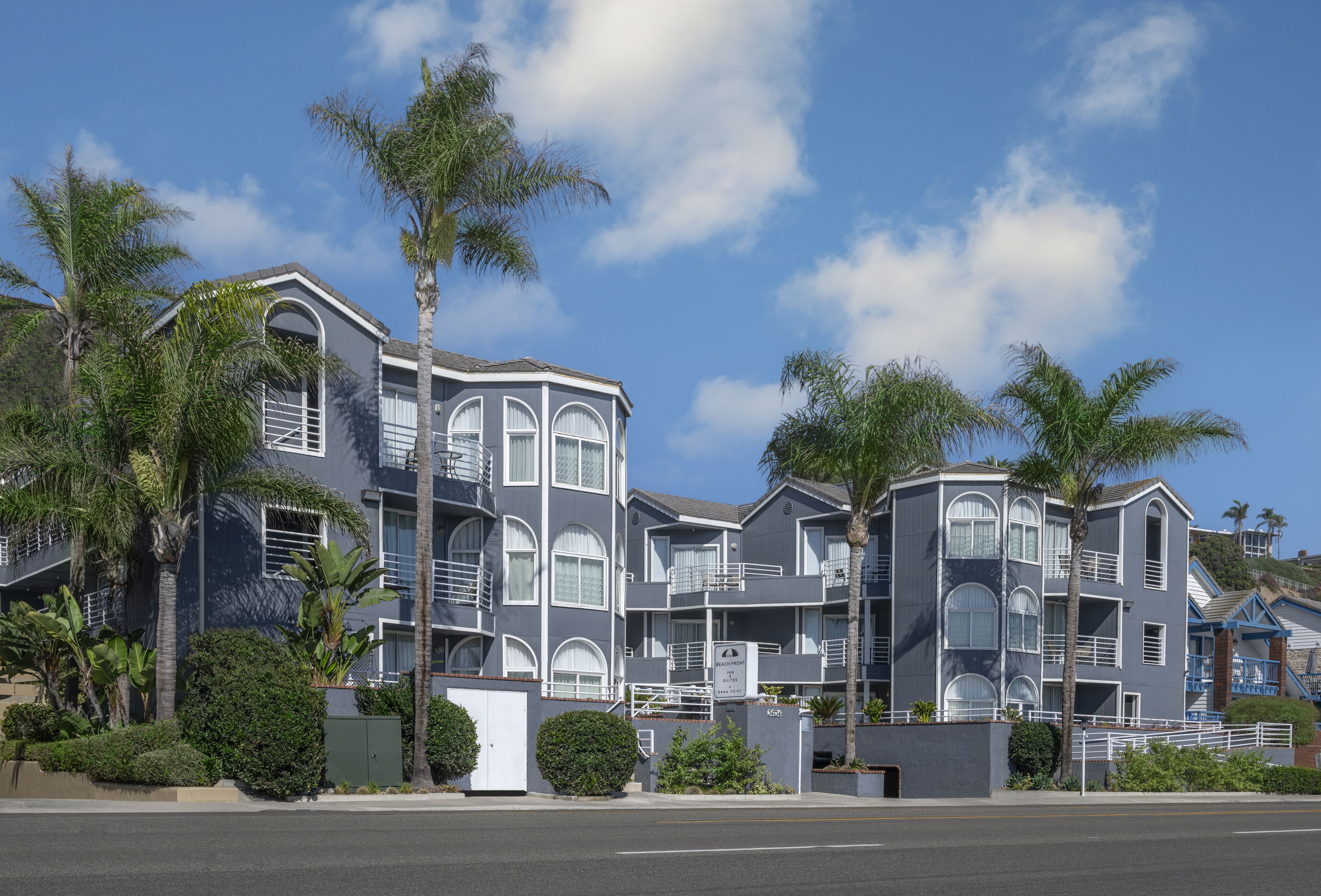 A multi-story hotel with a modern architectural design, featuring balconies and large windows.