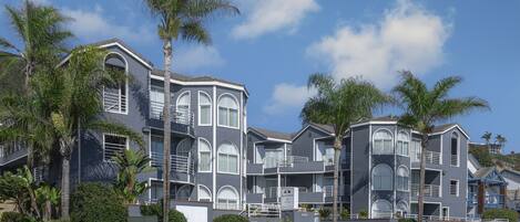 A multi-story hotel with a modern architectural design, featuring balconies and large windows.