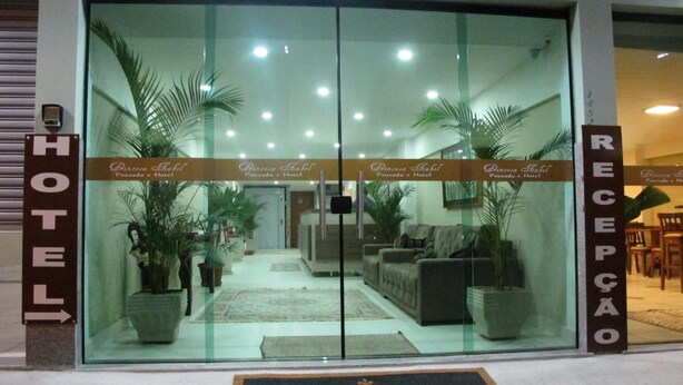 A hotel entrance with glass doors, potted plants, and a reception desk. - Princesa Isabel Pousada & Hotel - Rua Teresa (Petrópolis)