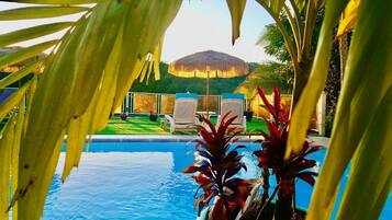 Una piscina al aire libre, sillones reclinables de piscina