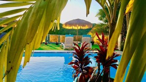 Una piscina al aire libre, sillones reclinables de piscina