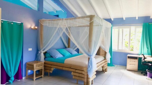 A bedroom with a four-poster bed, a desk, and a chair. - Maison d'hôtes Chez Adé Guadeloupe (Le Gosier)