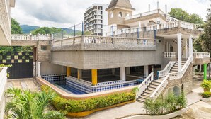 A multi-story building with a central courtyard, a tower, and a pool area.
