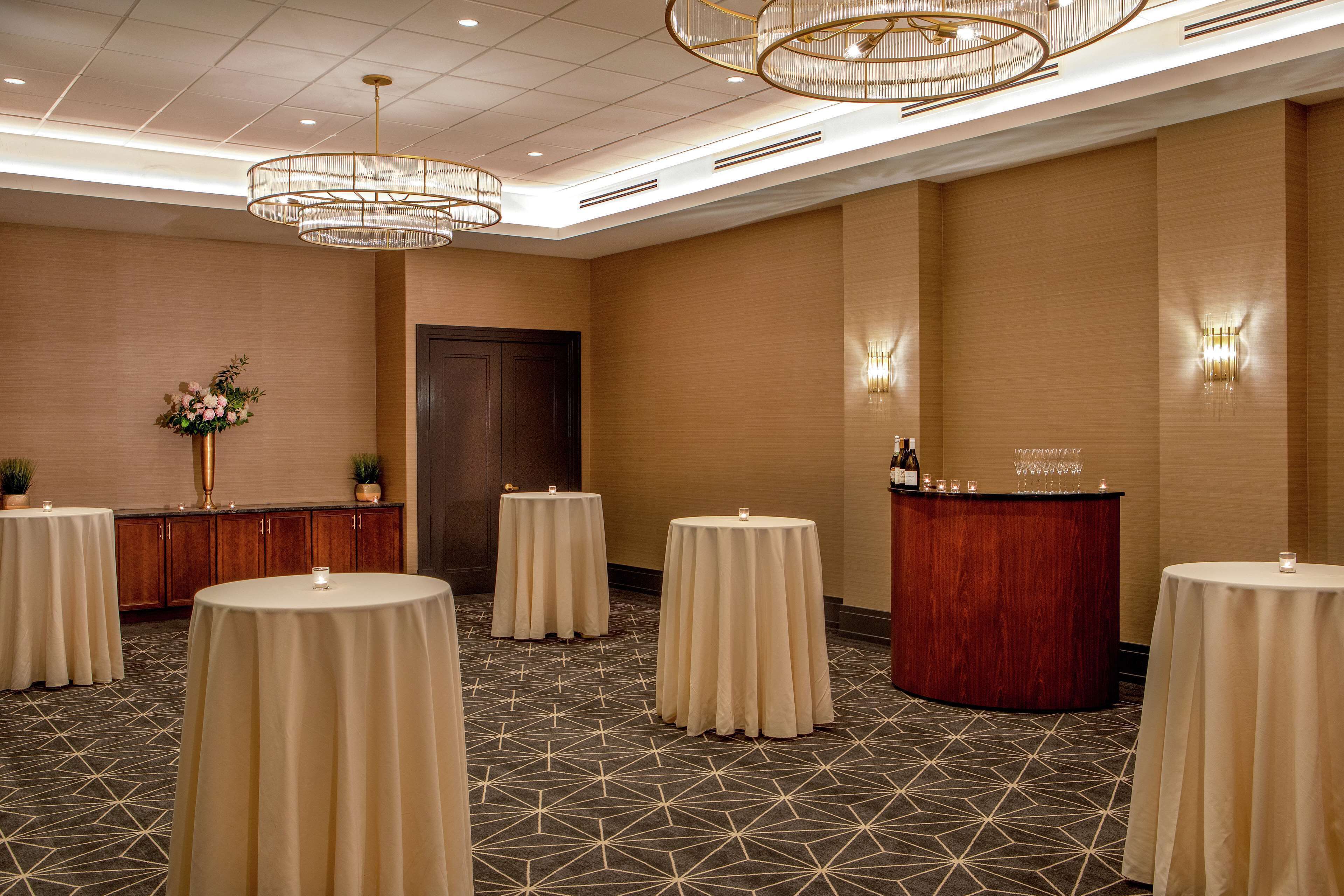 A conference room with round tables, a reception desk, and decorative lighting.