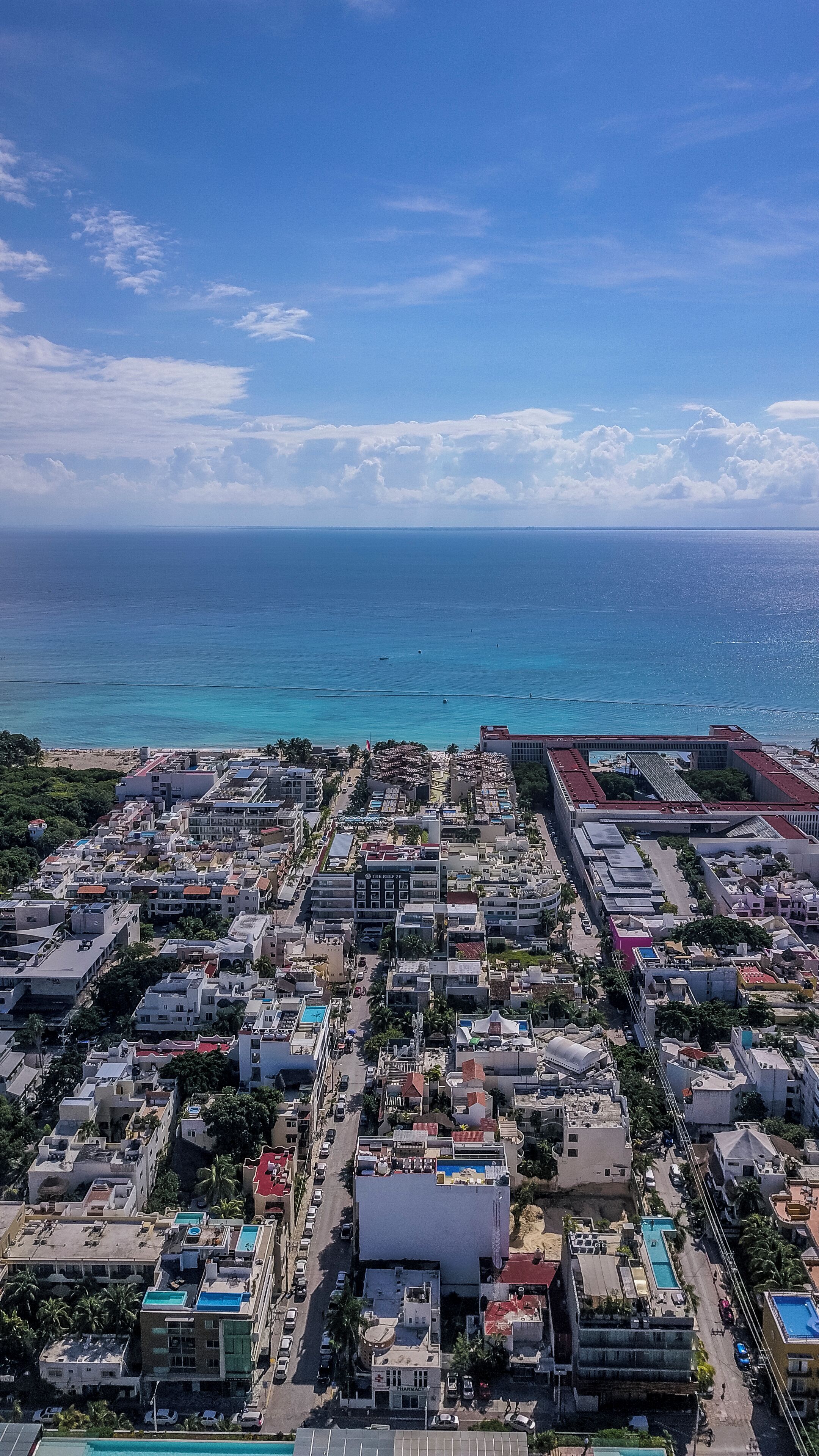 Vista aérea de una ciudad costera con edificios, carreteras y una playa.