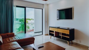 Uma sala de estar moderna com sofá de couro, mesa de centro de madeira, móvel de TV preto e ventilador de teto.