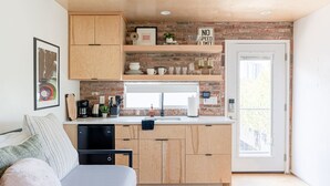 Una cucina compatta con mobili in legno, un forno integrato e una finestra.