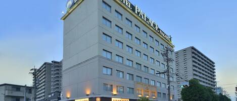 Un hotel de varios pisos con un letrero llamativo en la parte superior que dice "HOTEL PALACE NAGOYA".