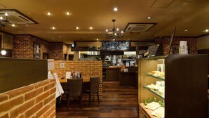 A restaurant interior with brick walls, wooden flooring, and a central dining area with chairs and a table. - Hotel Palace Nagoya (Nagoya)
