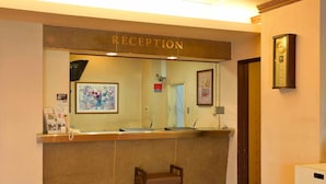 A reception area with a reception desk, a chair, a clock, and framed artwork on the wall. - Hotel Palace Nagoya (Nagoya)