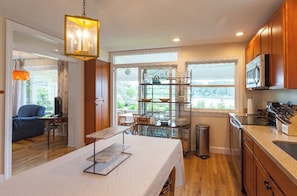 Enjoy meals in the kitchen with a large window offering a view of the outdoors, a refrigerator, microwave, and sink.
