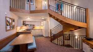 A multi-level interior with a wooden staircase, a kitchen area, and a dining space. - # Rustic, spacious, Ski-In-Ski-Out, Four Bedroom Chalet Apartment in Les Arc1950 (Bourg-Saint-Maurice)