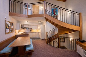 A multi-level interior with a wooden staircase, a kitchen area, and a dining space. - # Rustic, spacious, Ski-In-Ski-Out, Four Bedroom Chalet Apartment in Les Arc1950 (Bourg-Saint-Maurice)