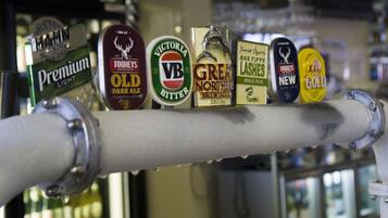 Een bar met verschillende biertaps, waaronder merken zoals Tooheys, Victoria en New.