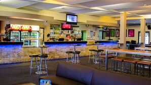 A bar area with stools, a counter, and a television screen. - Tenterfield Tavern and Motor Inn (Tenterfield)